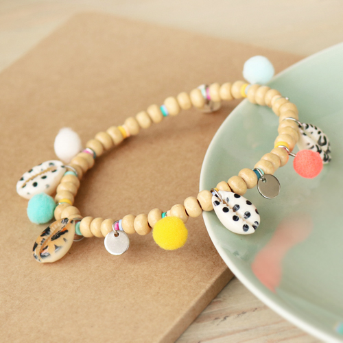 D&eacute;couvrez ici comment confectionner les plus beaux bijoux avec les perles Cauri et les pendentifs pompons :